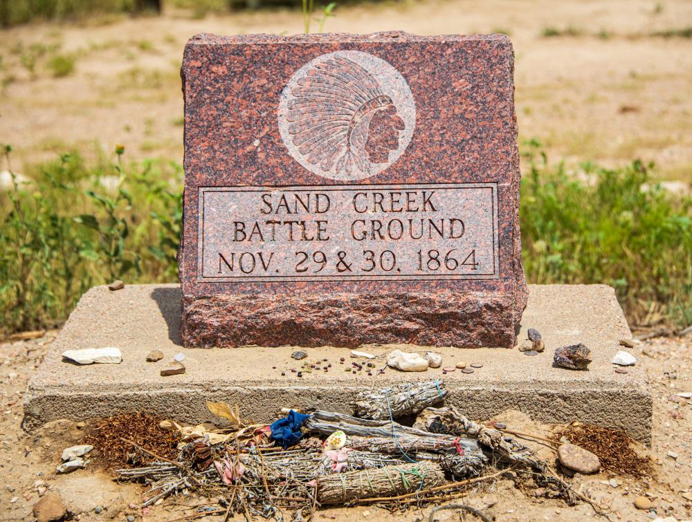 Monument reading "Sand Creek Battle Ground, Nov. 29 & 30, 1864" with rocks and other items left in front of it, Sand Creek Massacre National Historic Site, Colorado