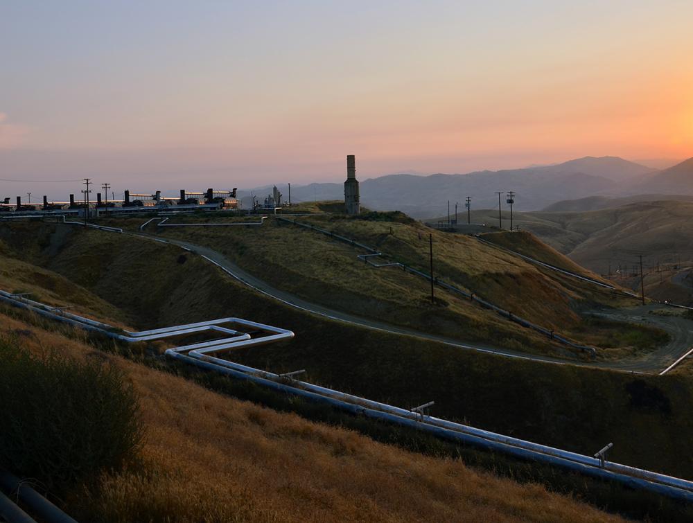  Oil and gas facility on a hill as the sun sets.