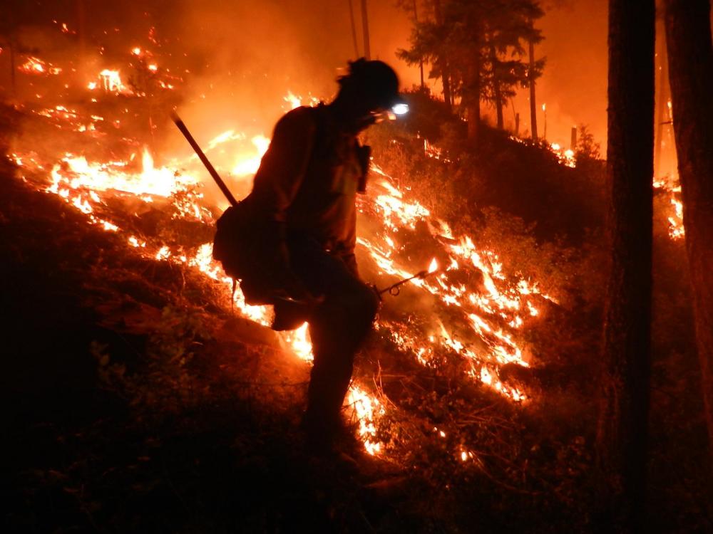 A firefighter in front of a wildfire in Lolo National Forest, Montana