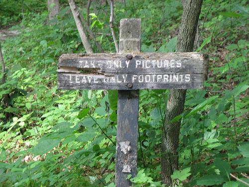 Sign in park that reads "Take only pictures. Leave only footprints"