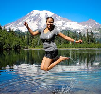 A person jumps with joy in a scenic lake