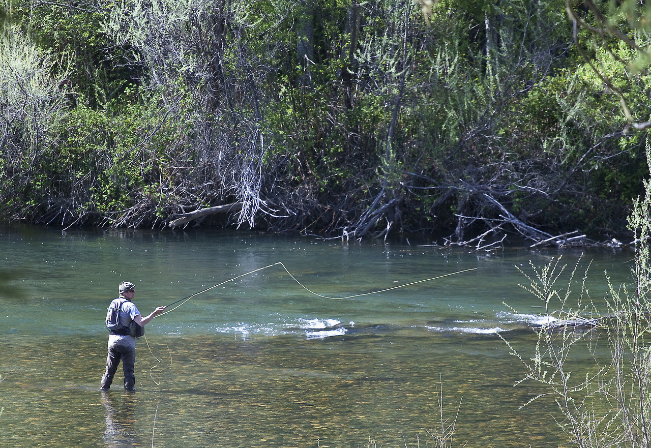 person casting long line at river