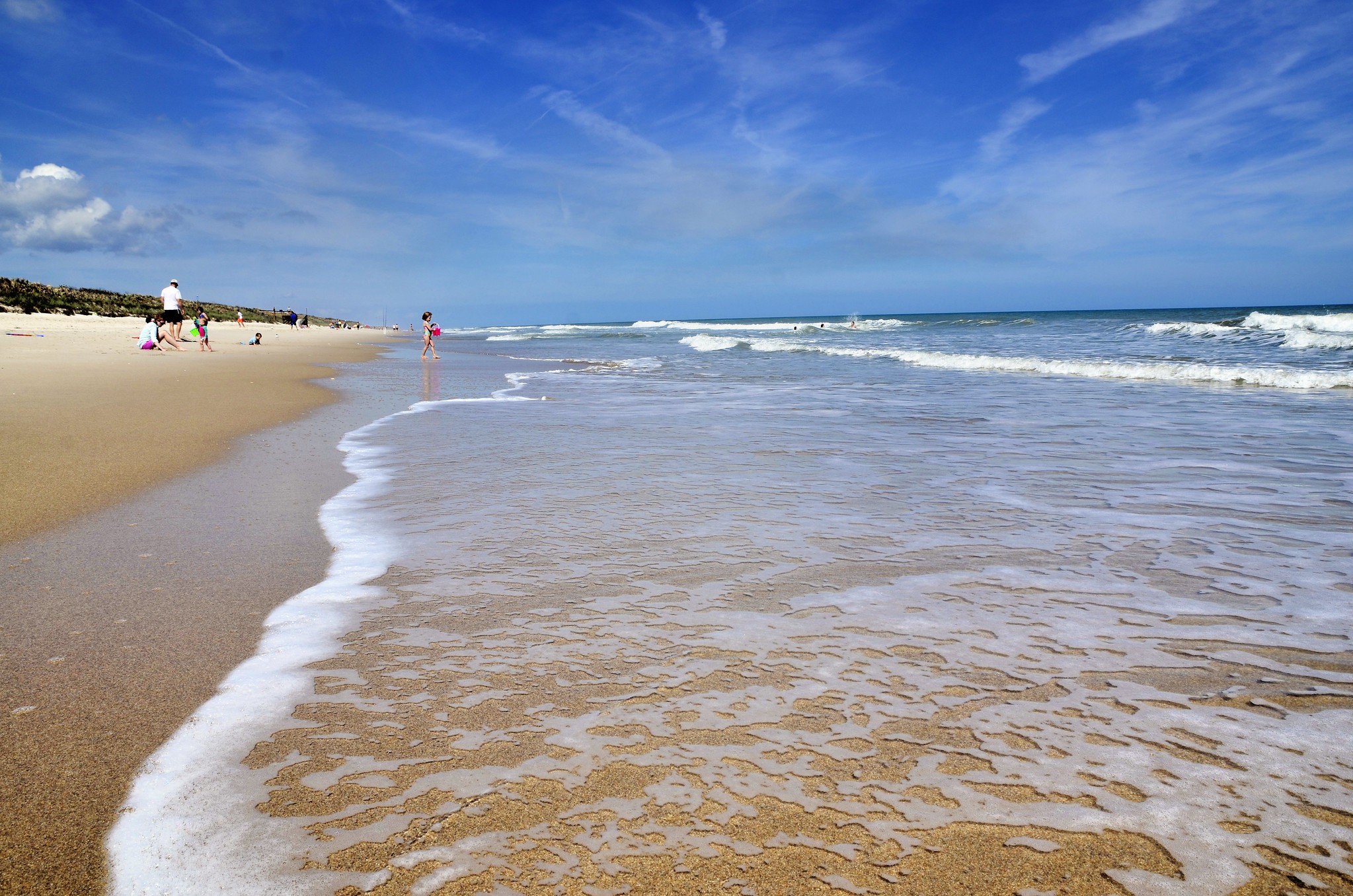 Beach with clear skies and a few people on the sand