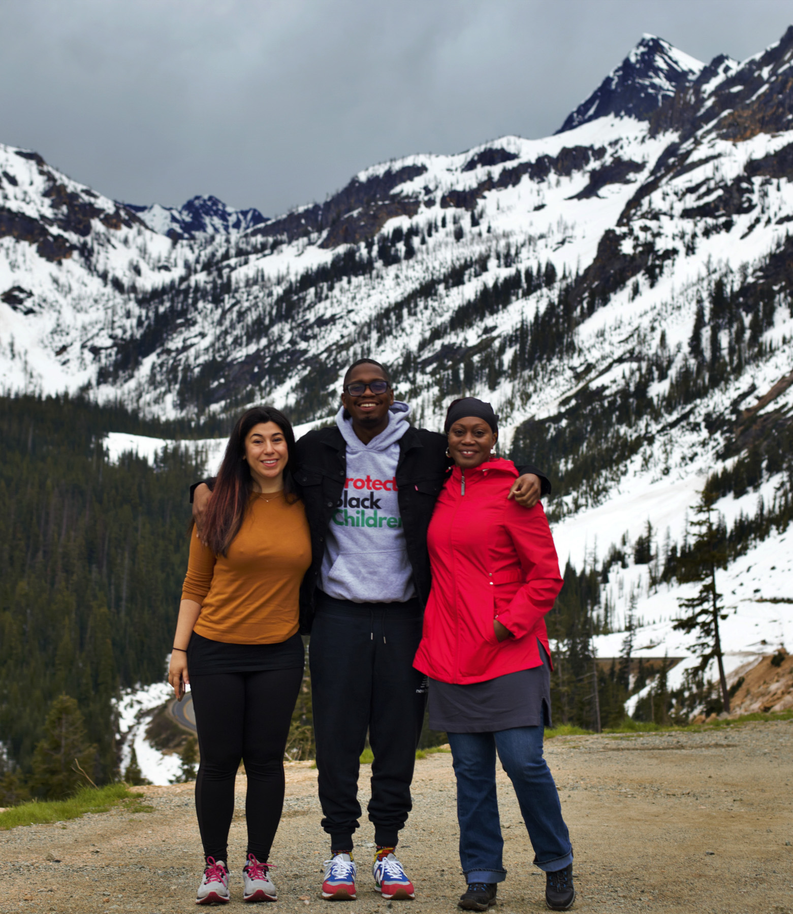 A group of hikers standing in front of snow-capped peaks.