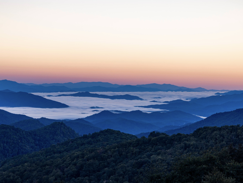 sunrise on top of mountains with clouds