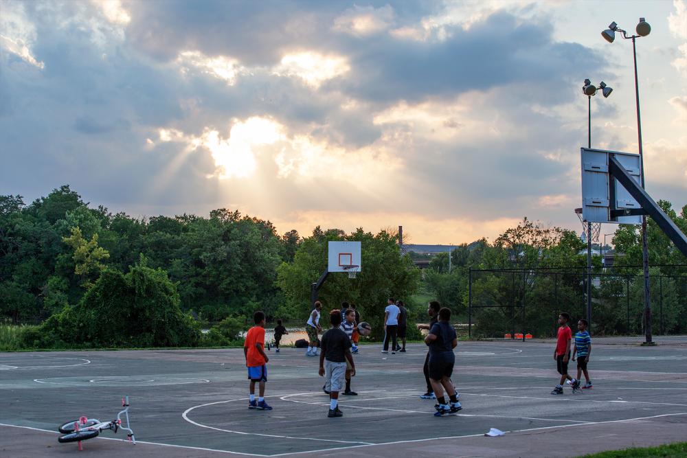 SUNSET OVER PEOPLE PLAYING BASKETBALL