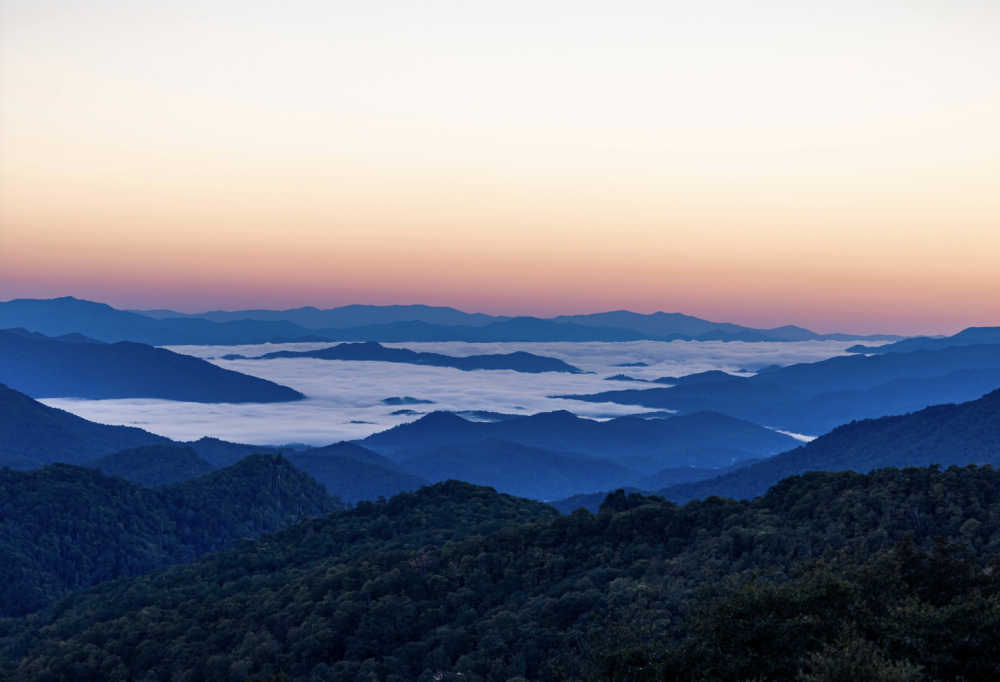 sunrise on top of mountains with clouds