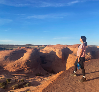 person looking towards the horizon at Arches National Park