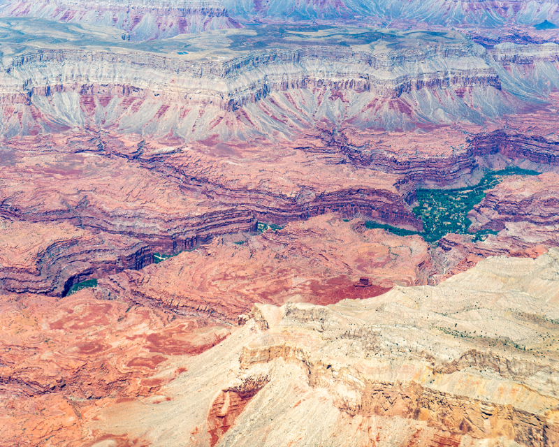 aerial view of red canyons and river flowing in between